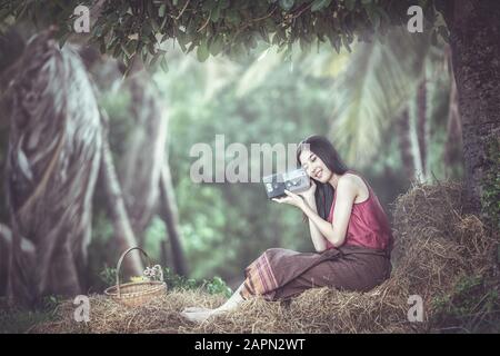 Femme à l'écoute de la radio dans la campagne de Thaïlande Banque D'Images