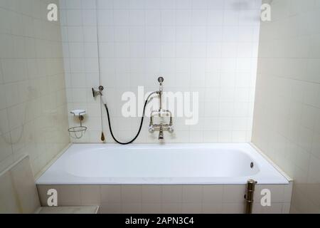 Belle salle de bain avec robinet d'eau chaude et froide, mur de carrelage blanc, architecture fonctionnelle moderne Banque D'Images