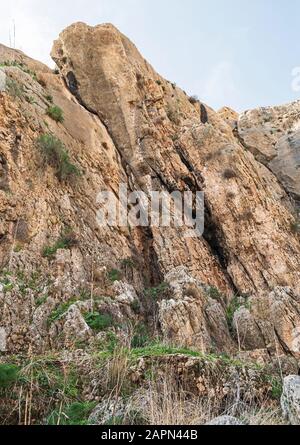 formation de roches calcaires inclinées près de ein prat dans wadi qelt dans la rive ouest avec des plantes dans les crevasses et les ruines d'un ancien aqueduc dans le fo Banque D'Images