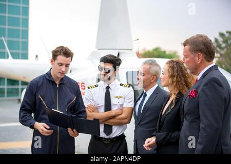 Le technicien signale le contrôle de l'hélicoptère au propriétaire d'une entreprise de service pilote et hélicoptère Banque D'Images