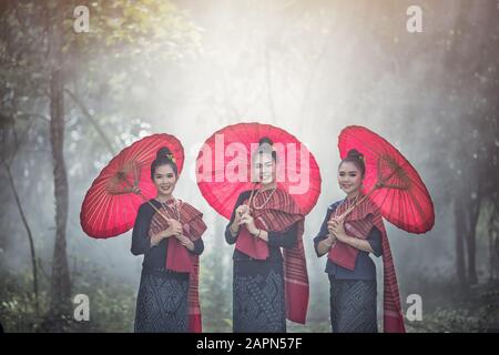 Portrait de Belles femmes thaïlandaises en costume traditionnel Phu-Thai, parapluie fait main faisant le style vintage en Thaïlande Banque D'Images