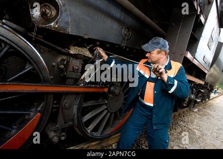 La plupart na Soči, Slovénie, 4 octobre 2008: Un homme nettoie un moteur à vapeur allemand Henschel & son 1944 à La gare La Plus na Soči. La locomotive est l'une des deux qui tire un vieux train de musée sur la ligne de chemin de fer de Bohinj (Transalpina) construite de 1900 à 1906 comme la connexion la plus courte de l'Empire austro-hongrois avec la mer Adriatique à Trieste (Italie). Banque D'Images