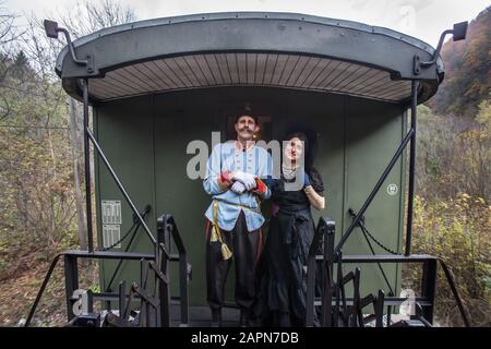 Bled, Slovénie, 4 novembre 2017: Les acteurs jouant à l'Archiduc autrichien Franz Ferdinand et son escorte posent pour une photo sur la plate-forme ouverte entre les calèches d'un train muséal vieux de cent ans qui fonctionne sur la ligne ferroviaire de Bohinj (Transalpina). La ligne a été construite de 1900 à 1906 comme la connexion la plus courte de l'Empire austro-hongrois avec la mer Adriatique à Trieste (Italie). Il a été inauguré en 1906 par l'Archiduc Franz Ferdinand qui a également voyagé sur cette ligne. La reconstitution de l'événement fait maintenant partie d'une visite en train. Banque D'Images