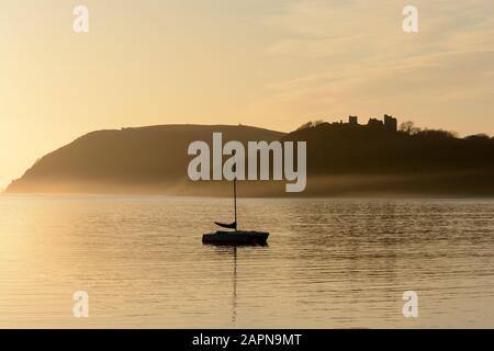 Château de Llansteffan et bateau à voile en début de soirée brouillard coucher de soleil Tywi Estuaire Carmarthenshire Pays de Galles cymru Royaume-Uni Banque D'Images