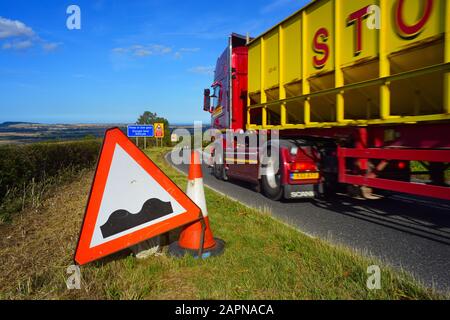 un camion passant devant un panneau d'avertissement de route bosselée/de cahules devant staxton hill yorkshire royaume-uni Banque D'Images
