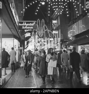 Shopping animé à Kalverstraat à Amsterdam dans le cadre du festival proche de Sinterklaas Date: 29 novembre 1965 lieu: Amsterdam, Noord-Holland mots clés: Éclairage de fête, public, magasins Banque D'Images