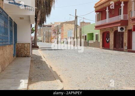 Une rue principale déserte à l'heure de la sieste avec des boutiques et des maisons colorées bordant la route à Santa Maria, Sal, Cap Vert, Afrique Banque D'Images