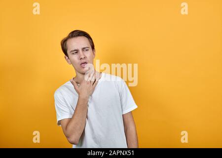 L'homme a tourné la tête vers le côté et tousse avec sa bouche ouverte Banque D'Images