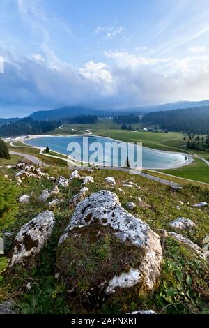 Le lac et les prairies au col de la Coe : base du musée Tuono sur la droite, Mont Maggio en arrière-plan. Folgaria, Cimbra Alp, Trentin, Italie. Banque D'Images