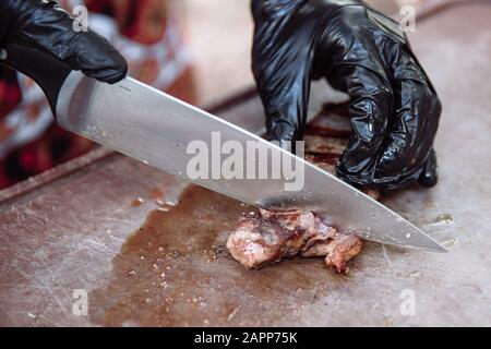 Mains Chef slicing steak juteux avec un couteau. Banque D'Images