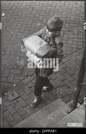 Pénurie de charbon au début de l'hiver. Lorsque vous devez acheter le charbon à une bourse médiocre, cela se produit dans des sacs en papier. Sur le chemin de la maison avec nouveau stock Date: 13 décembre 1955 lieu: Amsterdam, Noord-Holland mots clés: Population, charbon, hivers Banque D'Images