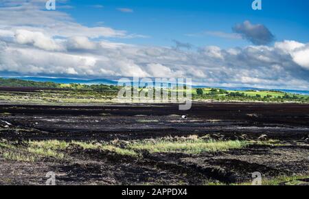 Un Bord na Mona découper bog utilisés pour l'extraction de tourbe près de Birr, County Offaly, l'Irlande, avec des montagnes de Slieve Bloom dans l'arrière-plan Banque D'Images