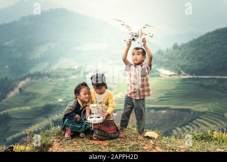 MU CANG CHAI, VIETNAM - SEP 22 , 2016 : enfant exploitant une drone voler ou planant par télécommande dans la campagne du Vietnam Banque D'Images