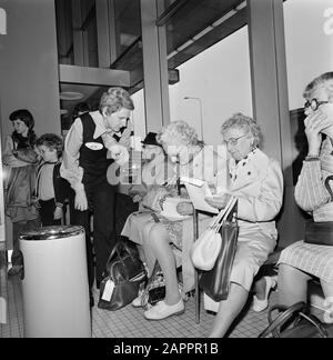 Les participants à un voyage de la fondation "Nous venons" à Schiphol. La fondation "Nous venons" a organisé des voyages bon marché pour donner aux gens l'occasion de visiter leurs parents émigrés. La fondation a été fondée par Maurits Reckman, aéroports Date : 20 mai 1975 lieu : Noord-Holland, Schiphol mots clés : personnes âgées, aéroports Banque D'Images