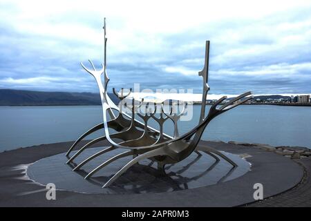 Monument Sun Voyager, monument historique de la ville de Reykjavik, conçu par Jon Gunnar Arnason, à la soirée du printemps avec mer et montagnes en arrière-plan Banque D'Images