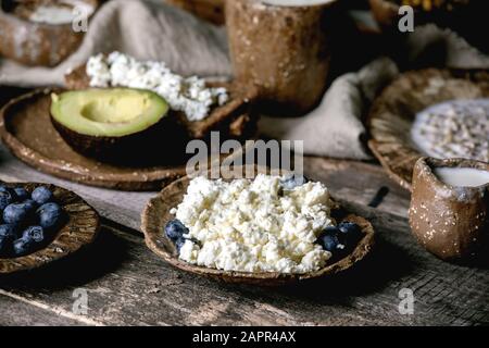 Petit déjeuner sain. Assortiment de plats de petit déjeuner composé de blé, yaourt, kéfir, fromage cottage, avocat, pain de seigle, graines, noix et baies i Banque D'Images
