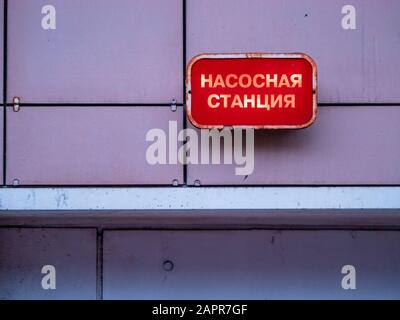 Plaque industrielle rouge avec lumière sur le mur du bâtiment au-dessus de l'entrée du sous-sol avec l'inscription en russe - station De Pompage. Mosc Banque D'Images