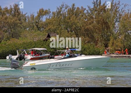Mangroves et bateaux à moteur au large de la côte de Maurice. Banque D'Images