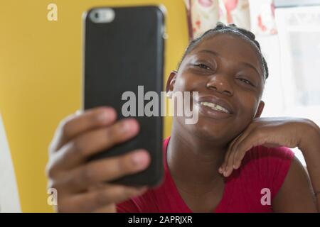 Adolescent souffrant du trouble bipolaire regardant le téléphone Banque D'Images