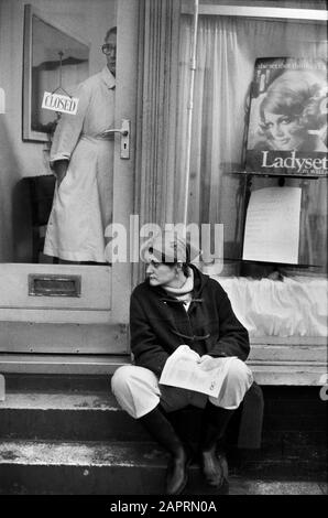 Faites des achats dans le centre de Londres en passant par une démonstration. Femmes coiffeurs, démonstrateur se trouve sur la marche regardant déprimé. 1970 Londres 1976 Angleterre HOMER SYKES Banque D'Images