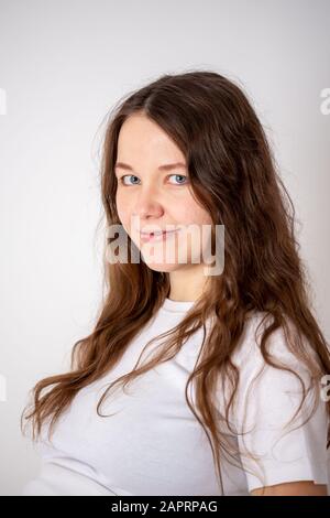 La jeune belle femme enceinte éprouve de fortes émotions sur un fond blanc Banque D'Images