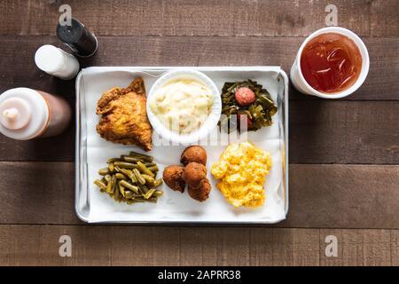 Un plateau de poulet frit, de haricots verts, de mac et de fromage avec du thé sucré Banque D'Images