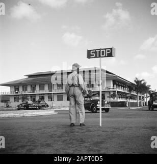 Voyage au Suriname et aux Antilles néerlandaises un agent de police avec un panneau d'arrêt au siège de la raffinerie de pétrole du CPIM sur l'île de Curaçao Date: 1947 lieu: Curaçao mots clés: Bâtiments , police, raffineries, panneaux routiers Banque D'Images