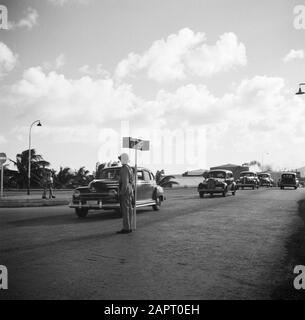 Voyage au Suriname et aux Antilles néerlandaises un agent de police avec un panneau d'arrêt au siège de la raffinerie de pétrole du CPIM sur l'île de Curaçao Date: 1947 lieu: Curaçao mots clés: Voiture, voitures, panneaux, police, raffineries, panneaux routiers, police de la circulation Banque D'Images