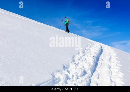 Femme ski de fond, escalade de la montagne dans la peau de piste, sur des skis et des peaux dans Hatcher's Pass, Alaska, Talkeetna Mountains Banque D'Images