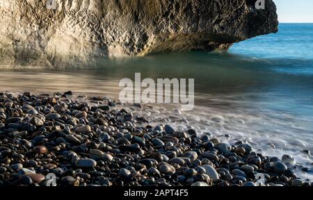 Low angle view of paysage marin avec des vagues de vent des éclaboussures sur le rocher et la mer de cailloux. Rocher d'Aphrodite à Paphos, Chypre. Banque D'Images