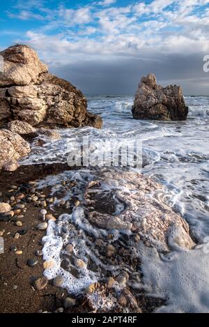 Avec les vagues de vent marin pendant les conditions météorologiques à l'espace littoral rocheux du rocher d'Aphrodite dans la région de Paphos, Chypre. Banque D'Images