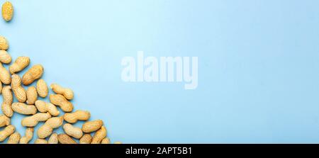 Cadre en noix arachides en coquille avec espace de copie sur fond bleu. Plat avec place pour le texte pour le beurre d'arachide, la pâte d'arachide. Végétalien Banque D'Images