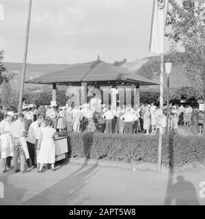 Moselle: Fête du costume et du vin soirée goers à la Weinbrunnen avec une sculpture décorée de tonneau de vin, juste en face d'un chariot de glace Date: 4 juillet 1959 lieu: Allemagne, Kröv, Rhénanie-Palatinat, Allemagne de l'Ouest mots clés: Sculptures, comans de glace, costume, public, festivals folkloriques, vin Banque D'Images