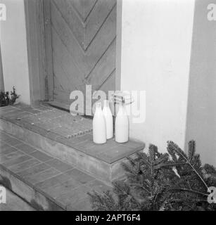 Jour dans la vie de la famille Svendsen bouteilles de lait et paquets de beurre se tiennent sur le trottoir à la porte d'entrée Date: Mars 1954 lieu: Danemark mots clés: Beurre, vie quotidienne, portes, lait, bouteilles de lait, tuiles, maisons Banque D'Images