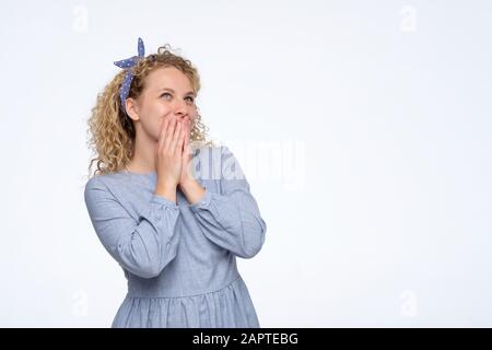 Jeune fille rêvante avec des cheveux blond et frisés à la recherche. Studio tourné Banque D'Images