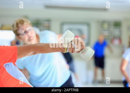 Instructeur de poids libres dans un cours de fitness senior Banque D'Images