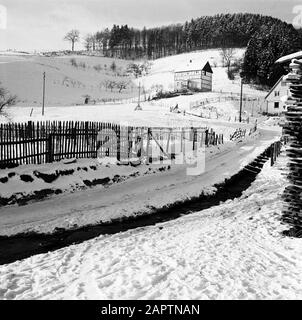 Rothaargebergte Paysage Vallonné avec route de village, clôtures et maisons à colombages en hiver Date: Non dédallé lieu: Allemagne, Girkhausen, Rhénanie-du-Nord-Westphalie, Allemagne de l'Ouest mots clés: Panoramas, neige, routes, hiver Banque D'Images