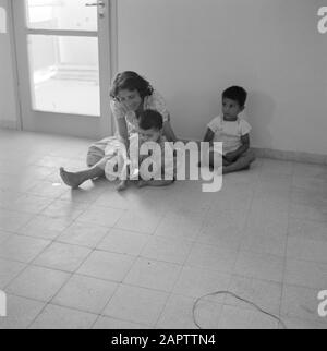 Dans un nouveau quartier résidentiel de Dimona. Une femme avec deux jeunes enfants Date: 1er janvier 1963 lieu: Dimona, Israel, Negev mots clés: Enfants, mères, revêtement de sol, maisons Banque D'Images