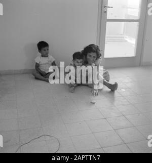 Dans un nouveau quartier résidentiel de Dimona. Une femme avec deux jeunes enfants Date: 1 janvier 1963 lieu: Dimona, Israel, Negev mots clés: Enfants, mères, maisons Banque D'Images