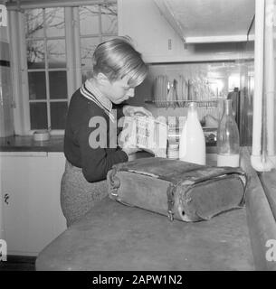 Jour dans la vie de la famille Svendsen Boy fait du porridge pour le petit déjeuner prêt Date: Mars 1954 lieu: Danemark mots clés: Vie quotidienne, ménage, intérieurs, cuisines, enfants, repas, lait, bouteilles de lait, vaisselle, maison, nourriture, maisons, fils Personname: Svendsen, Banque D'Images