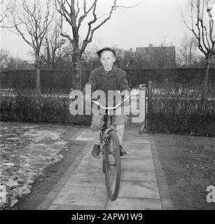 Jour dans la vie de la famille Svendsen Boy sur le vélo sur un chemin de jardin Date: Mars 1954 lieu: Danemark mots clés: Vie quotidienne, vélos, enfants, tuiles, jardins, fils Nom personnel: Svendsen, Banque D'Images