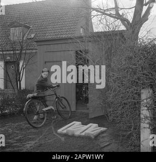 Jour dans la vie de la famille Svendsen Boy avec vélo sur un chemin de jardin près d'une grange et de casiers à vélos Date: Mars 1954 lieu: Danemark mots clés: Vie quotidienne, vélos, étagères à vélos, enfants, granges, jardins, habitations, fils Nom personnel: Svendsen, Banque D'Images