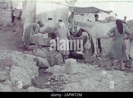 Grèce photo couleur (pâle) des femmes, un cheval et un homme à un lieu de boisson et de lavage dans un village Date: 1 Janvier 1930 lieu: Grèce mots clés: Chevaux, femmes, approvisionnement en eau Banque D'Images