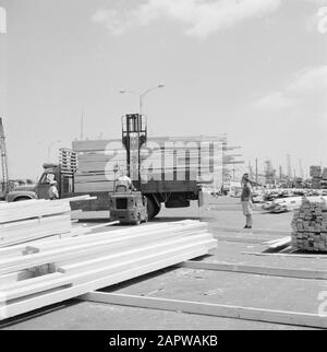 Israël 1964-1965: Haifa, Port Cargo de bois est déplacé au port avec un chariot élévateur et un camion Annotation: Haifa est une ville portuaire et station balnéaire dans le nord d'Israël, dans la partie la plus au nord des montagnes Carmel et sur la Méditerranée Date: 1964 lieu: Haifa, Israël mots clés: activité, personnel portuaire, chariots élévateurs, quais, chargement et déchargement Banque D'Images