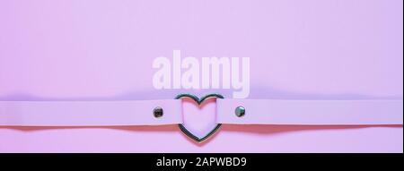 Chancre en cuir rose avec coeur en métal. Concept Saint Valentin Banque D'Images