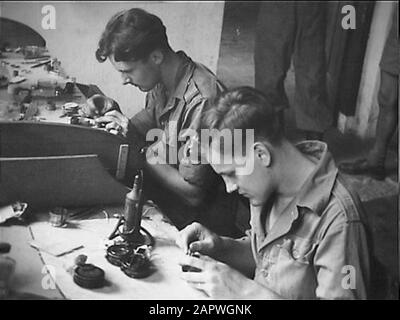 Medan. Il faut beaucoup de mains pour garder l'équipement de l'armée en mouvement sur la route. Le Service technique de l'Armée de terre sait comment en parler. Des dizaines d'ateliers dans tout l'archipel remplissent la tâche importante d'entretenir et de réparer le matériel. Le service optique requiert une expertise approfondie de la part de son personnel. Au premier plan, le compacteur G. Zondag de Geldermalsen. A côté de lui, le horloger H.Scheurman de Haarlem. Date: Juin 1948 lieu: Indonésie, Indonésie, Medan, Hollandais East Indies mots clés: Horlogers, compacteurs, ateliers Nom personnel: Scheurman H., Sunday G. institution Banque D'Images