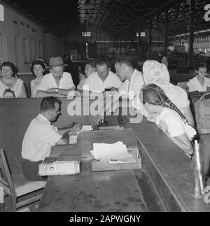 Israël 1964-1965: Haifa, arrivée des navires à passagers; le douane remplit les papiers alors que les voyageurs regardent au comptoir Annotation: Haifa est une ville portuaire et station balnéaire dans le nord d'Israël, dans la partie la plus au nord des montagnes du Carmel et sur la mer Méditerranée. En 1945, les lignes ZIM (compagnie maritime) ont commencé comme expéditeur d'immigrants juifs dans le nouvel état d'Israël et sont devenues l'une des plus grandes compagnies maritimes du monde avec des succursales dans le monde Date: 1964 lieu: Haifa, Israël mots clés: Arrivée et départ, douanes, ports, pilotes, etc voyageurs Banque D'Images