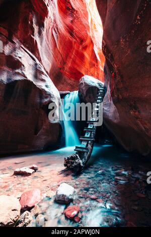 Longue exposition de cascade qui coule le long de marches rocheuses dans un étroit canyon Banque D'Images
