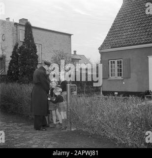 Jour dans la vie de la famille Svendsen M. Svendsen est accueilli par ses enfants à la clôture du jardin, surtout lorsqu'il arrive à la maison du travail Date: Mars 1954 lieu: Danemark mots clés: Goetingen, vie quotidienne, filles, familles, enfants, parents, maison, jardins, pères, maisons, fils Nom personnel: Svendsen, Banque D'Images