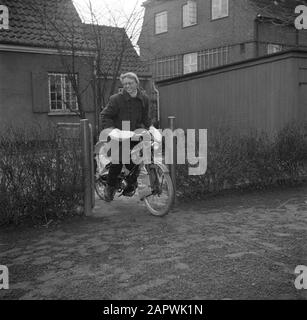 Jour dans la vie de la famille Svendsen Mme Svendsen sur son vélo avec moteur auxiliaire sur le chemin du jardin de sa maison Date: Mars 1954 lieu: Danemark mots clés: Vie quotidienne, vélos, motos, jardins, femmes, maisons Nom personnel: Svendsen, Banque D'Images